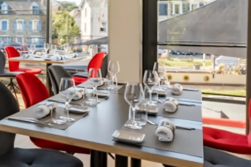 Salle du restaurant Essentiel, tables dressées devant les baies vitrées