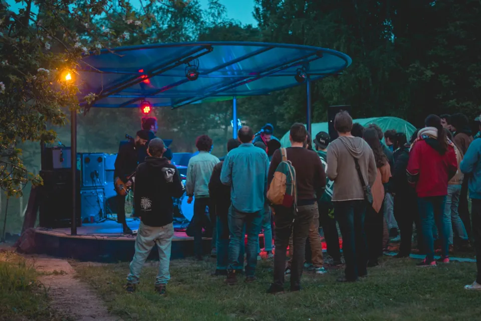 Soirée en plein air à la Ferme de Quincé, public devant la scène sous les arbres